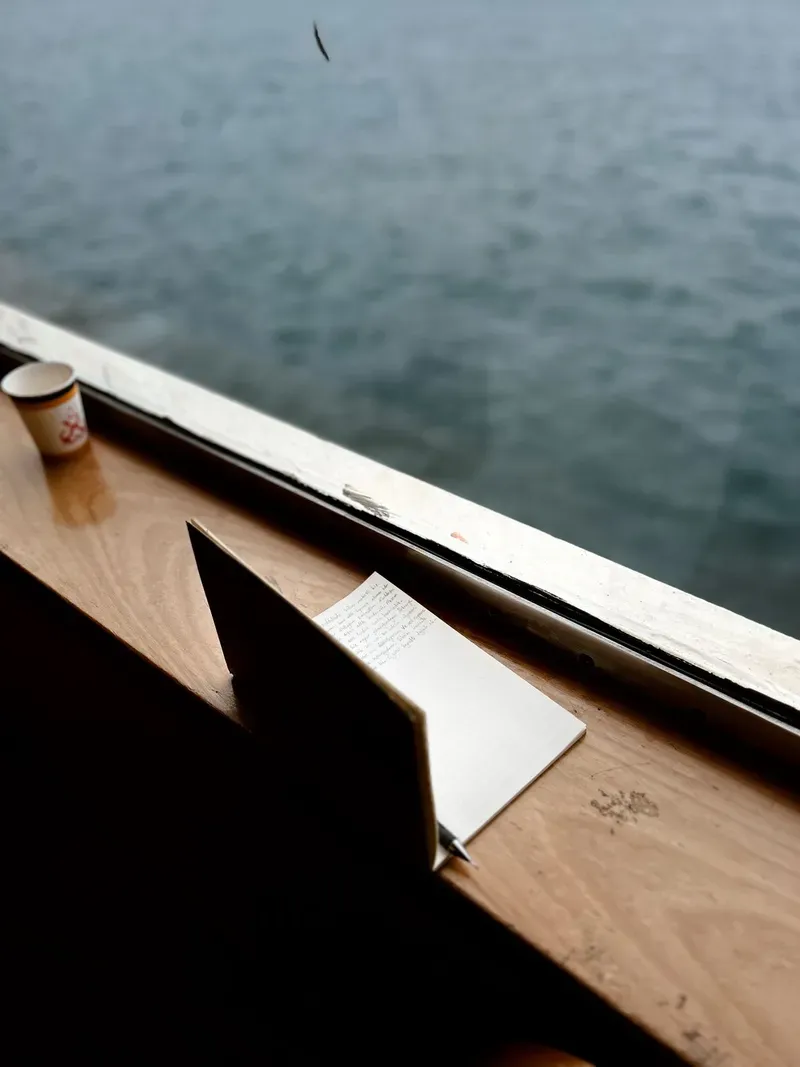 A notebook and cup of coffee by a window, ready for a structured repair conversation.