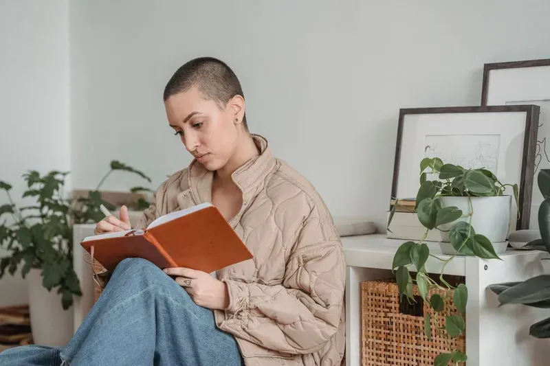 A person writing in a journal at home, a common way to process the aftermath of betrayal.